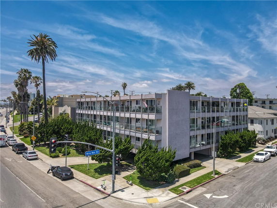 Front view of a multi-story apartment building located at a street corner.