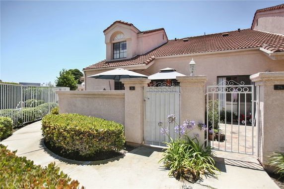 Front view of a house with a gated entrance and tiled roof.