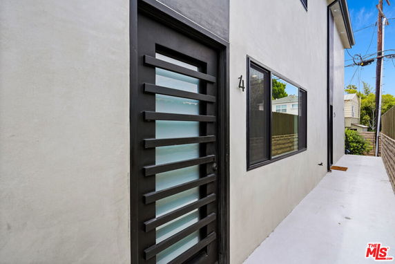 Front view of a modern two-story house with a distinctive black entry door and large windows.