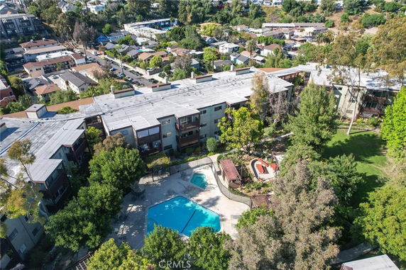 Aerial view of an apartment complex with a central swimming pool and surrounding greenery.