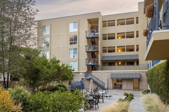 Front view of a multi-story building with outdoor seating area.
