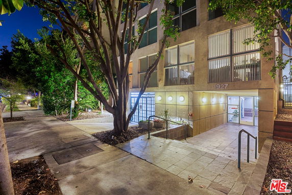 Front view of a multi-story building with a well-lit entrance at night.