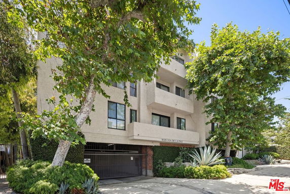 Front view of an apartment building with multiple floors and an entrance.