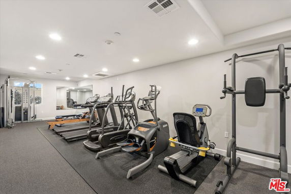 Indoor gym area with various exercise equipment including treadmills and weight machines.