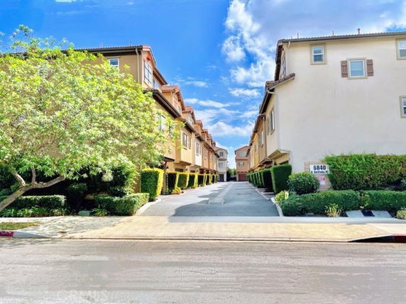 Front view of a row of three-story houses with a driveway in between.
