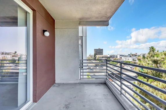 Balcony with railing overlooking cityscape and trees