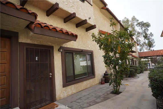 Front view of a two-story building with red-tiled roof and wooden beams.