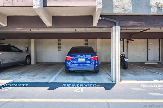 Covered parking area with reserved spaces for cars and a motorcycle.