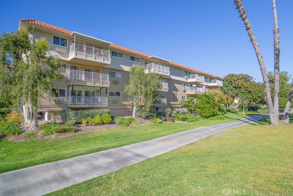 Front view of a multi-story apartment building with balconies.