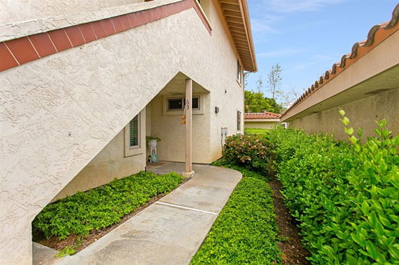 Front view of a multi-story house with a sloped roof and archway entrance.