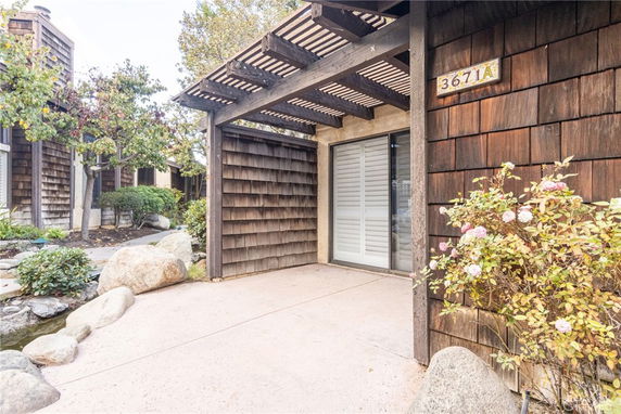 Front view of a house with natural wood siding and a covered entryway.