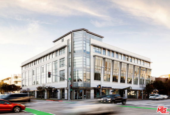 Front view of a multi-story commercial building with large glass windows.