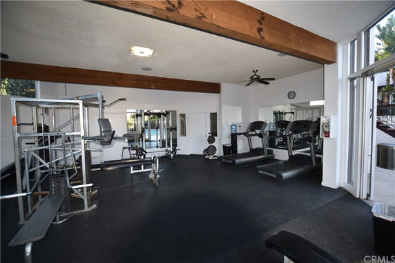 Indoor gym area with exercise equipment including treadmills and weight machines.