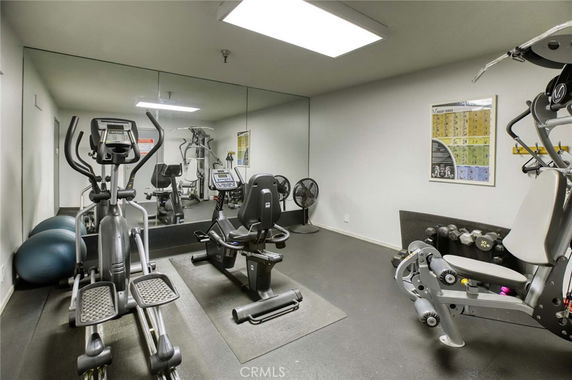 Indoor gym area with exercise equipment and mirrors.
