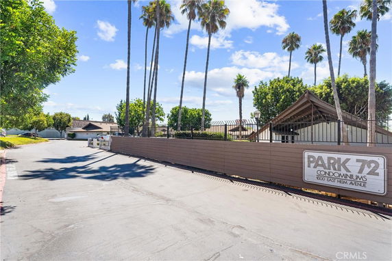 Entrance view of Park 72 Condominiums with trees and a pathway.