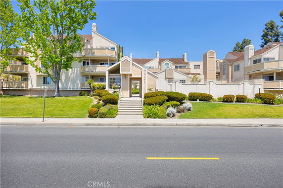 Front view of a multi-story residential building with landscaped grounds.
