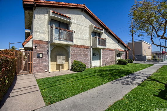 Front view of a two-story building with brick and stucco exterior and small balconies.