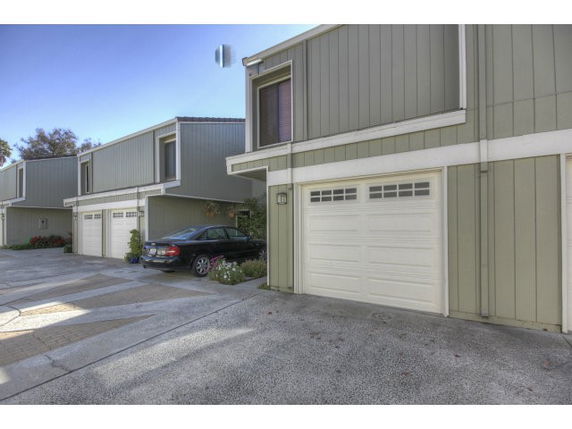 Front view of a row of attached townhouses with garages.