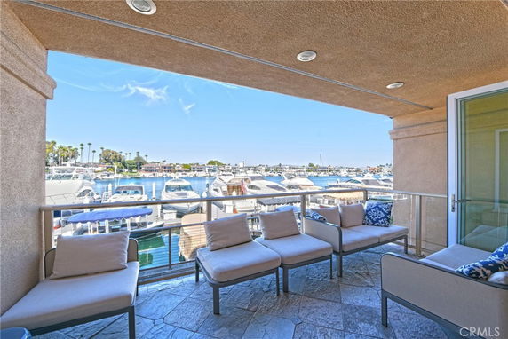 Balcony view overlooking a marina with multiple yachts and boats on a sunny day.