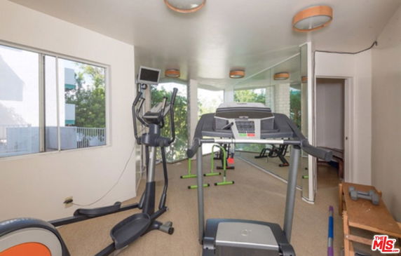 Indoor gym area with exercise equipment like a treadmill and elliptical.