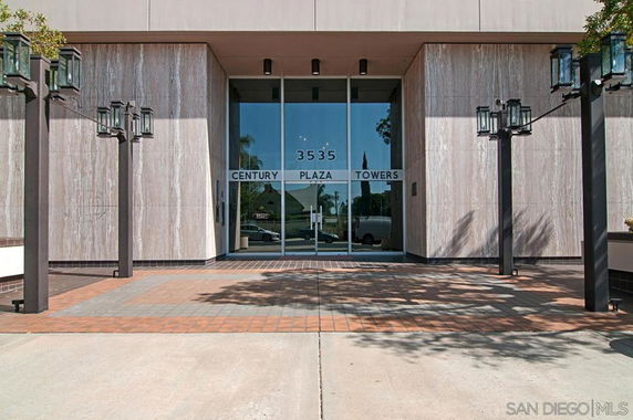 Front view of a building entrance labeled Century Plaza Towers with glass doors and surrounding lamp posts.
