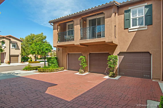Front view of a two-story house with a balcony and double garage.