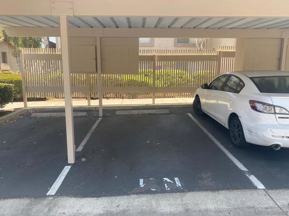 Covered parking area with a white car parked.