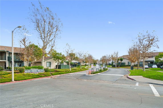 Front view of a residential complex entrance with multiple two-story buildings.