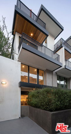 Front view of a modern multi-story building with cantilevered balconies.