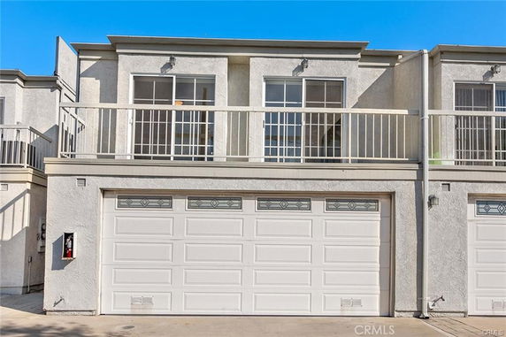 Front view of a two-story house with a double garage and balcony.