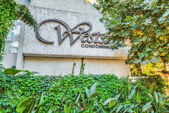 Front view of a building with a sign reading 'Westside Condominiums'.