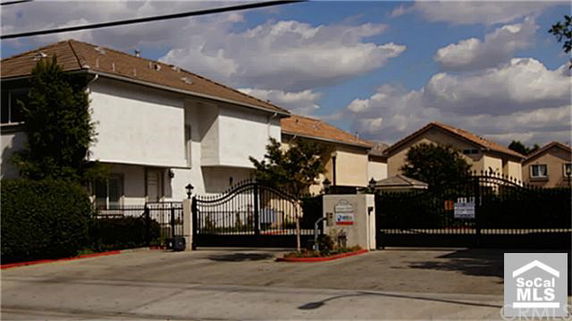 Front view of a gated residential building with a two-story structure.