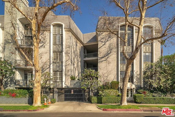 Front view of a multi-story residential building with balconies and large windows.