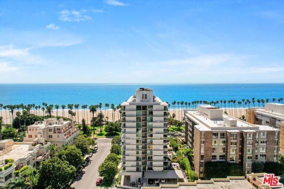 Panoramic view of buildings near a beach with ocean in the background.