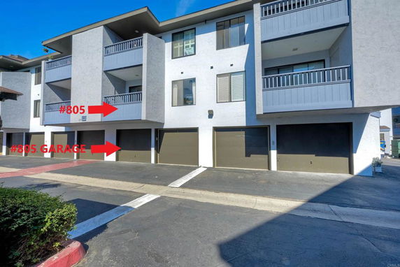 Front view of a multi-story building with garages on the ground level.