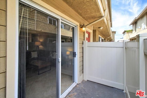 Exterior view of a patio area with sliding glass doors leading to the interior of a building.