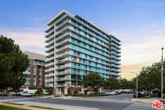 Front view of a multi-story apartment building with balconies.