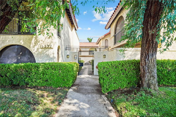 Front view of a two-story building with arched windows and a gated entry.