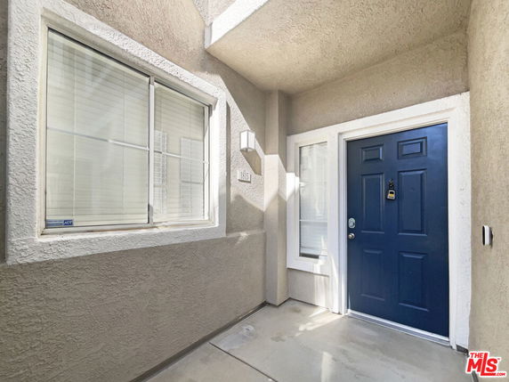 Front entrance of a house with a blue door and windows.