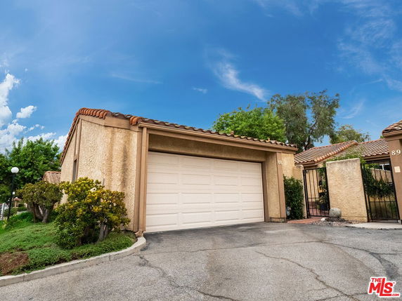 Front view of a house with a single garage and clay tile roof.