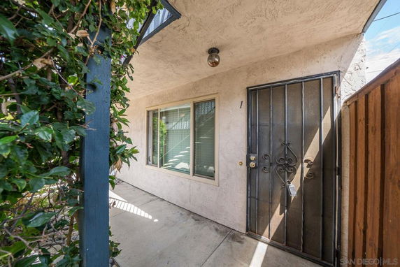 Front view of a building entrance with a metal security door and window.
