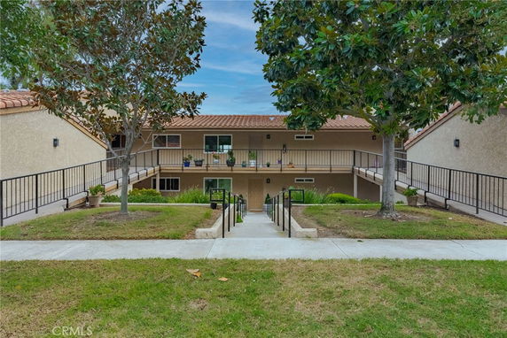 Front view of a two-story building with a central walkway and balconies.