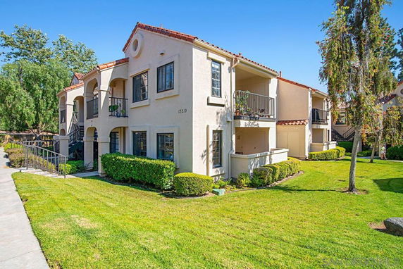 Front view of a two-story apartment building with balconies and a tile roof.