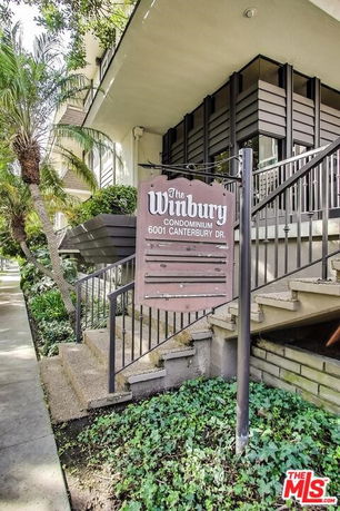 Front view of a condominium building with a sign for 'The Winbury, 6001 Canterbury Dr.'