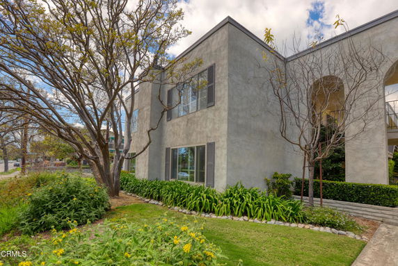 Front view of a two-story house with large windows and a garden.