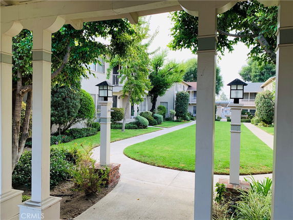 View of surrounding area with a pathway and green lawn in a residential complex.