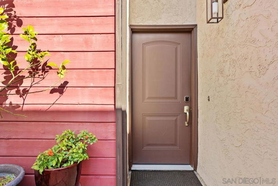 Exterior entrance of a house with a brown door and red siding.