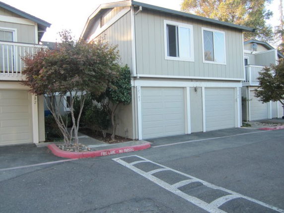 Front view of a two-story building with garages on the ground floor.
