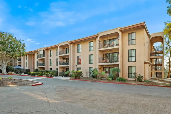 Front view of a three-story apartment building with balconies.
