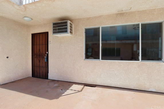 Exterior view of a building with a metal door and large window.